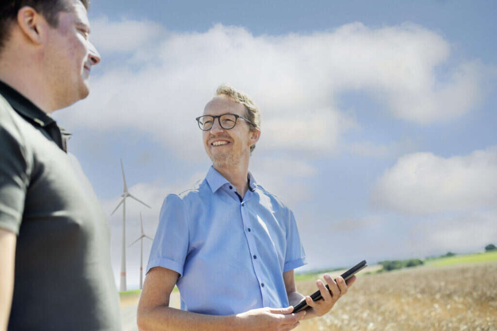 Fotografie eines Mitarbeiters von GAIA im Gespräch mit einem Flächeneigentümer zu Windenergieprojekten