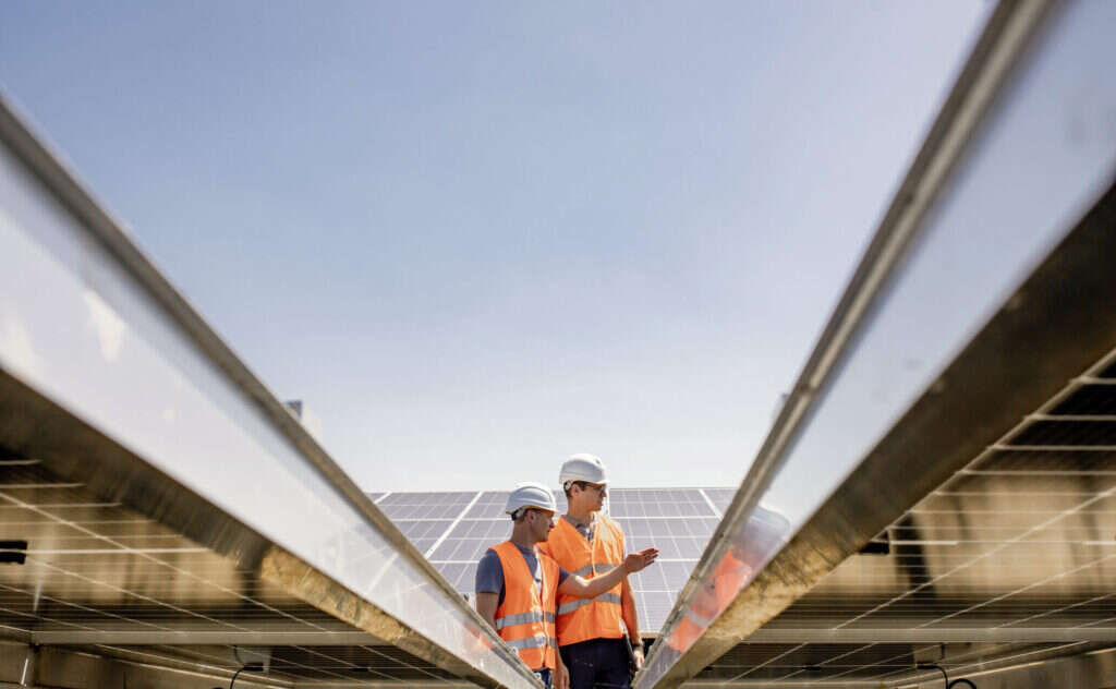 Fotografie von Mitarbeitern von GAIA umgeben von Photovoltaik Freiflächenanlagen